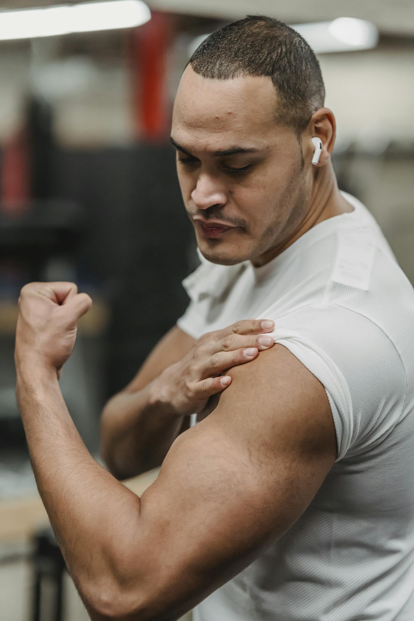 Fit man showcasing his bicep strength in a modern gym setting